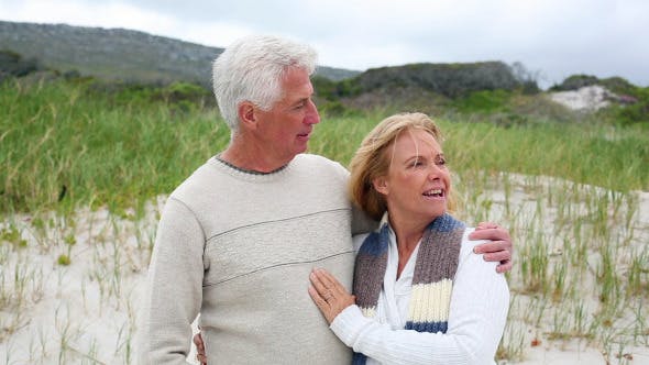 Smiling Retired Couple Standing On The Beach  - Download 8435982 Videohive